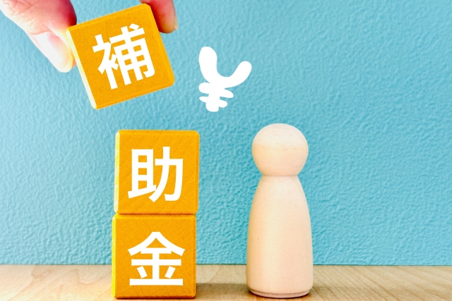 補助金と書かれたブロックと人の模型