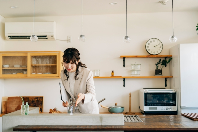キッチンをチェックする女性の営業スタッフ