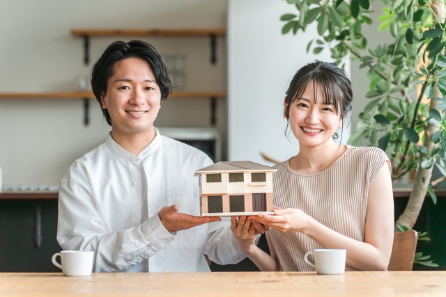 家の模型を持つ男女