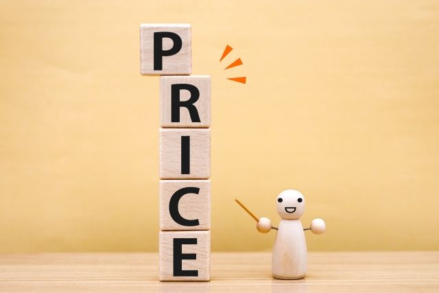 PRICEと書かれた木のブロックとそれを指差す木の人形