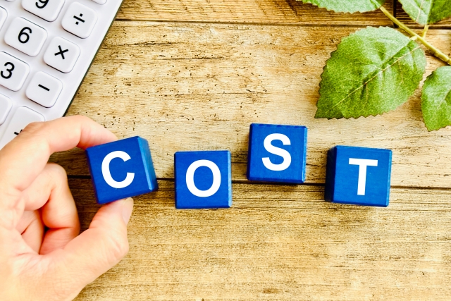 コストと書かれたブロックとそれを持つ手