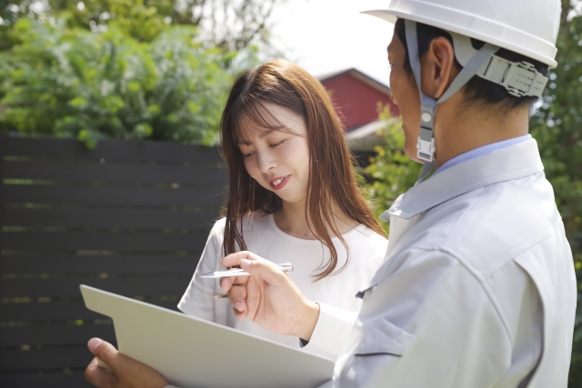 住宅の相談をしている作業員と女性