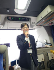 バスの中で司会をする人